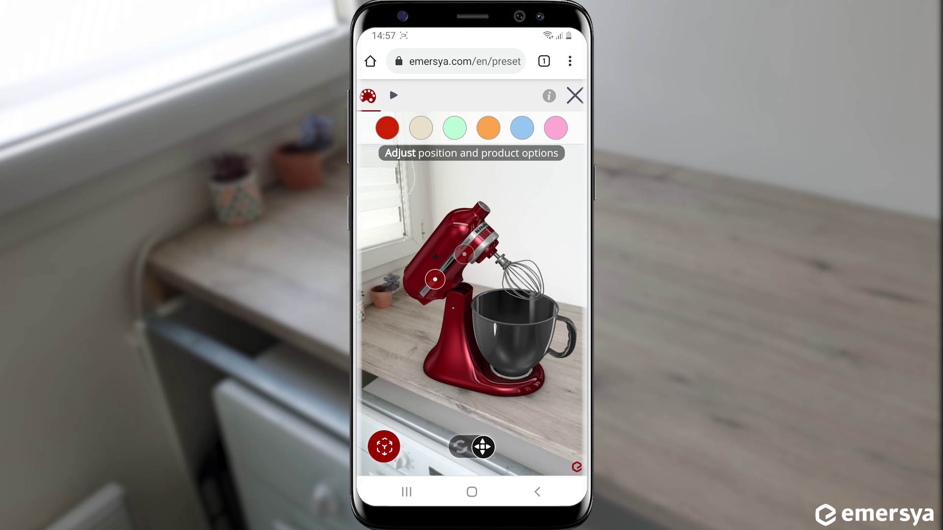 Customer trying out a red KitchenAid stand mixer in AR on their kitchen tabletop on their mobile device. Smartphone screen in the middle of the image, real-life scenery on the background. The model can be re-scaled and colors can be changed in real time to provide seamless high-end rendering.