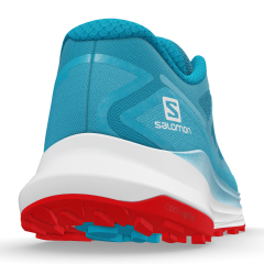 Back side view of a Salomon Ultra Glide shoe. Colors are sky blue for the textile part and white and red for the sole. There is a Salomon logo print on the right side. We can see the cleats on the sole.