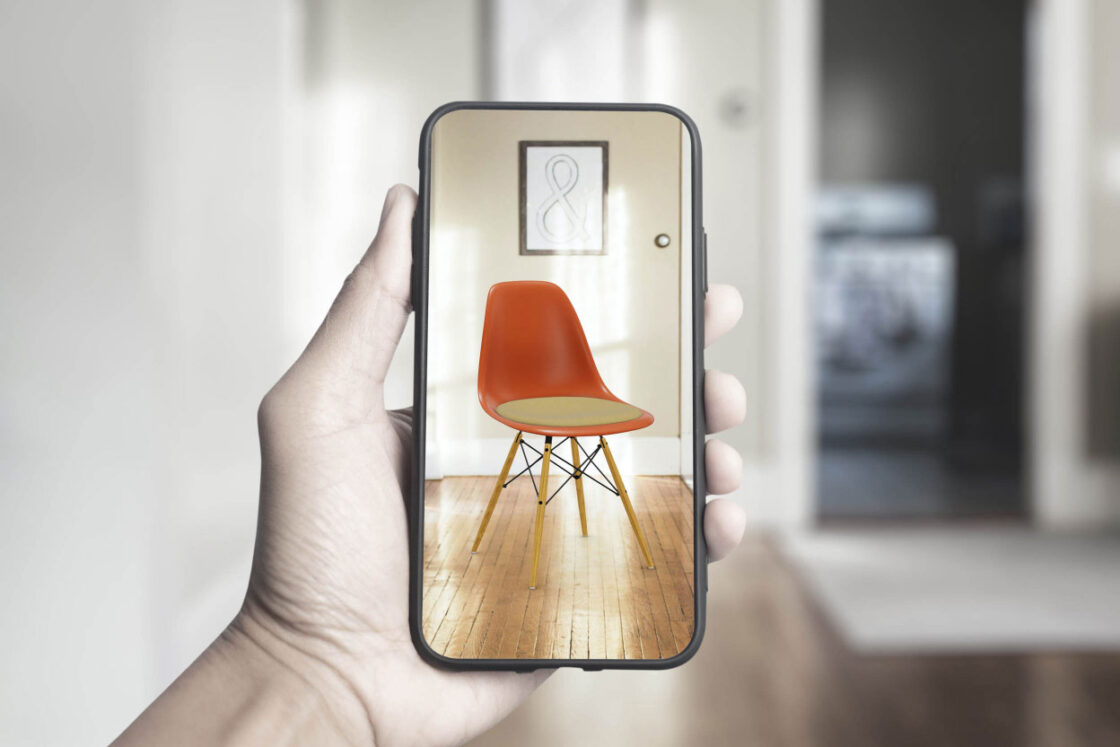 A customer is testing the Emersya augmented reality functionalities with a mobile phone. He placed the chair in a room using AR to see how it fits.