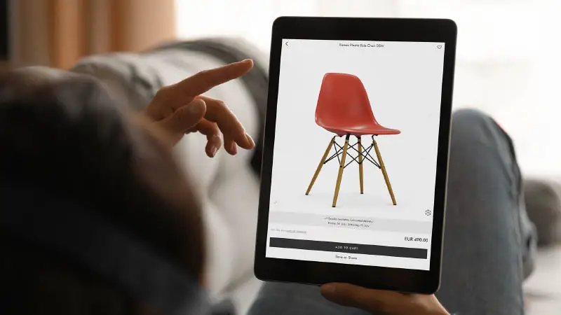 Picture presenting a customer trying different configurations of a Vitra eames chair with Emersya technology. He can choose live in real time 3D or AR different color of plastic shell and change the base. The price of the configuration is updated live and he can order directly